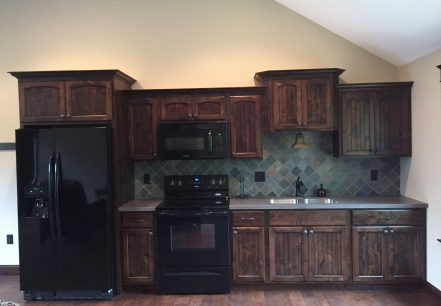 dark stained kitchen cabinets and black appliances