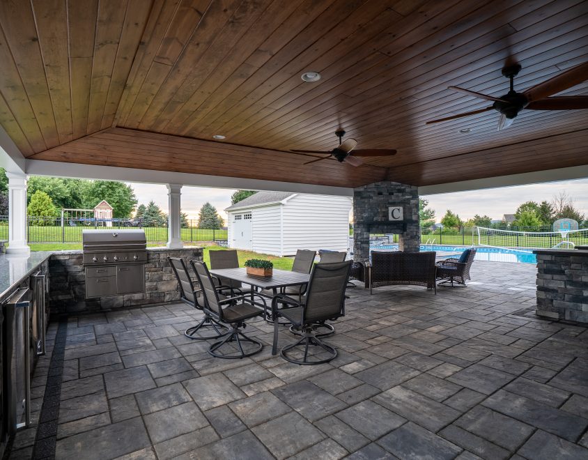 newly built backyard porch with stone flooring and dark wood ceiling