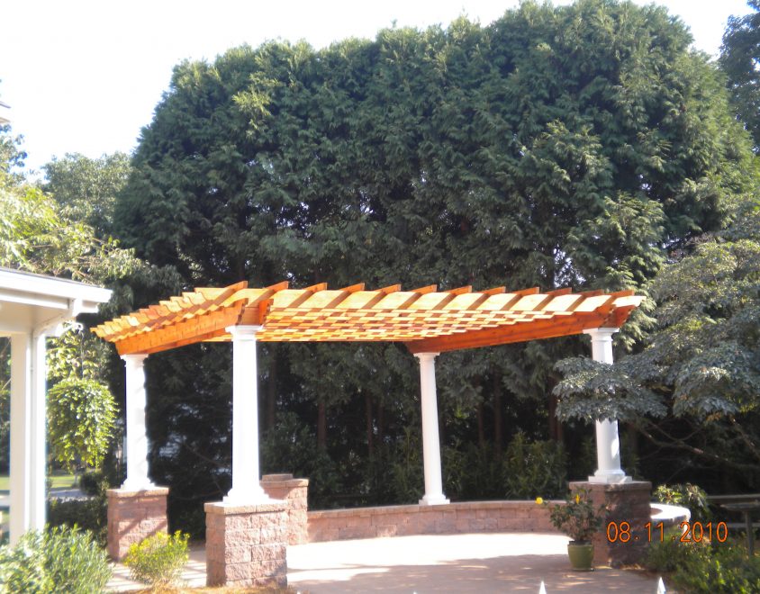 outdoor pergola with white columns and stone support