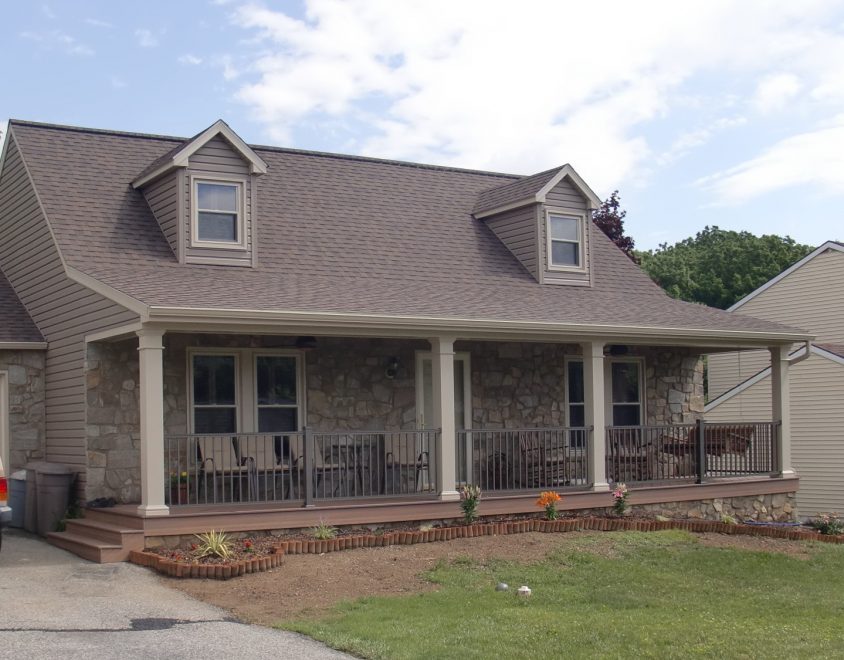 newly completed home enclosure project on house with stone siding and symmetrical windows