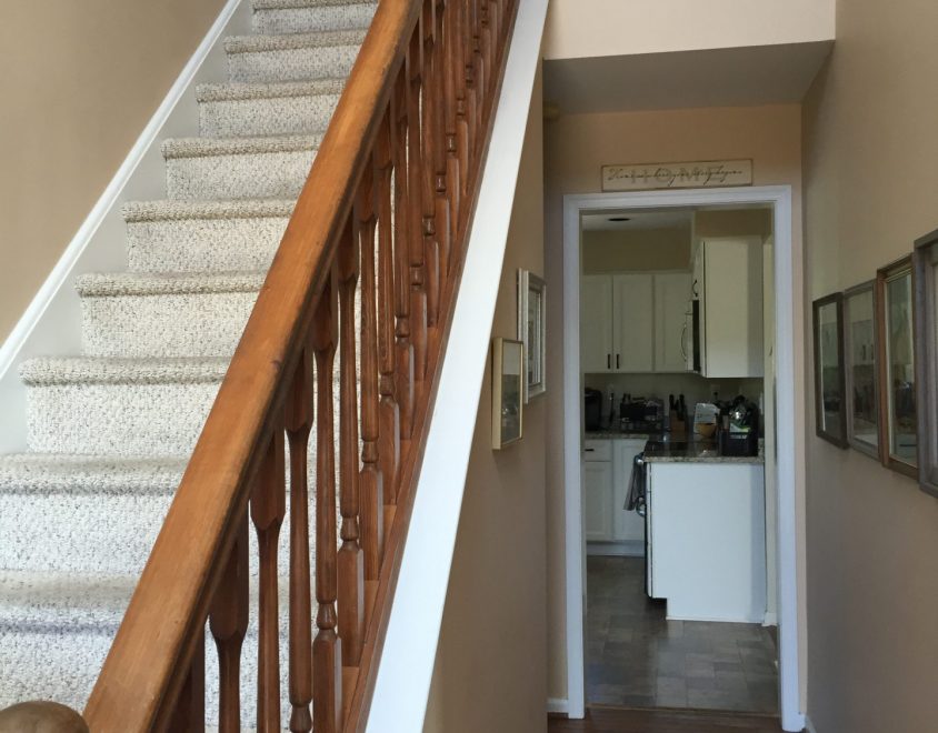 white carpet staircase with wood handrail